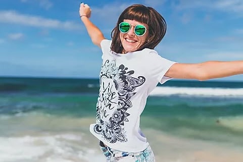 Woman with arms outstreched on a beach