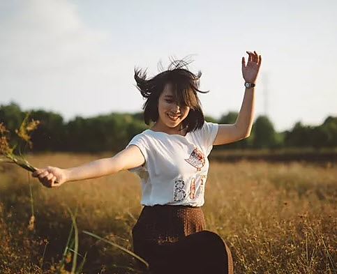 Woman in a field holding a plant